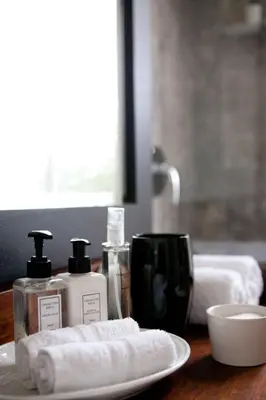 a table with two bottles of soap and a plate at Banksia Boutique Hotel & Spa in Cape Town