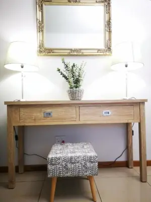 a wooden table with two lamps and a mirror at Cottage on Norwood in Cape Town