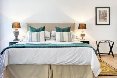 a bedroom with a large bed with two lamps at Maison Montagne in Franschhoek