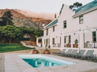 a house and a swimming pool in front of a house at Maison Montagne in Franschhoek