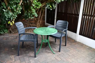 three chairs and a table and a table and chairs at Bradclin Sport Newlands in Cape Town