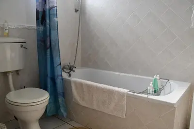 a bathroom with a toilet and a bath tub with a sink at Bradclin Sport Newlands in Cape Town
