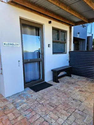 a door with a bench in front of a building at Kleinblom in Pringle in Pringle Bay