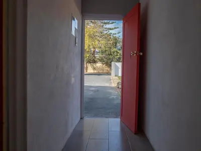 a red door leading into a hallway with a driveway at Lyronne Guest house, Shuttle and Tours in Cape Town