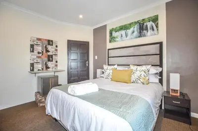 a bedroom with a large bed and a fireplace at Casa Milner Guest House in Cape Town
