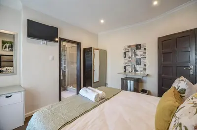 a bedroom with a bed with a television and a window at Casa Milner Guest House in Cape Town