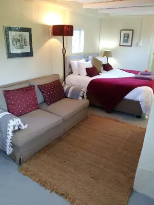 a living room with a couch and a bed at Cabernet Cottage Be Still and Know in Franschhoek