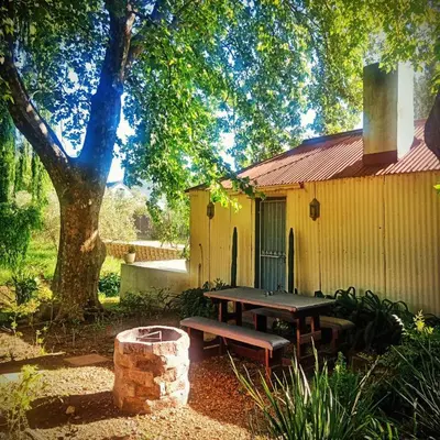 a picnic table and a bench in front of a building at Cabernet Cottage Be Still and Know in Franschhoek