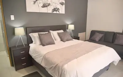 a bedroom with a large bed and a couch at 33onGill in Cape Town