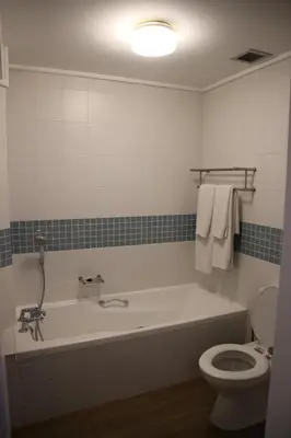 a bathroom with a bath tub and a toilet at The Boardwalk Accommodation in Gordonʼs Bay