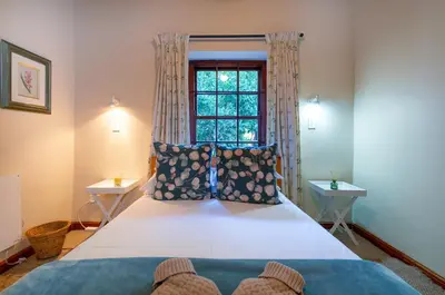a bedroom with a large bed with a window at GreyCot in Greyton