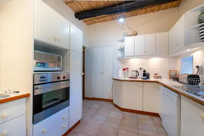 a kitchen with white cabinets and a stove top oven at GreyCot in Greyton