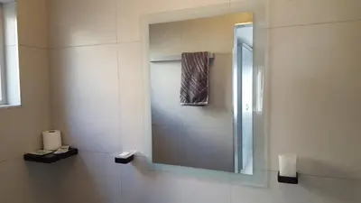 a bathroom with a shower and a mirror at Hayley's Place in Cape Town