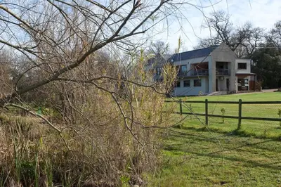 a house in a field with a fence at Viettz Suite Annex in Stellenbosch