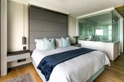 a bedroom with a large bed and a large mirror at Bayview 203 in Hermanus