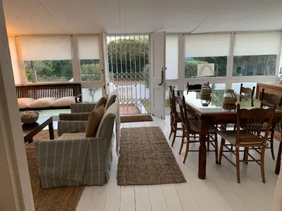 a living room with a table and a dining room at The Missions House in Hermanus