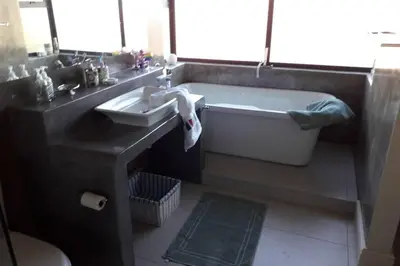 a bathroom with a bath tub and a sink at Moondust near the ocean, food and wine in Hermanus