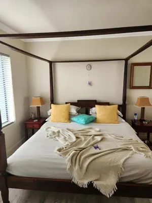 a bedroom with a large bed with yellow and green pillows at Moondust near the ocean, food and wine in Hermanus