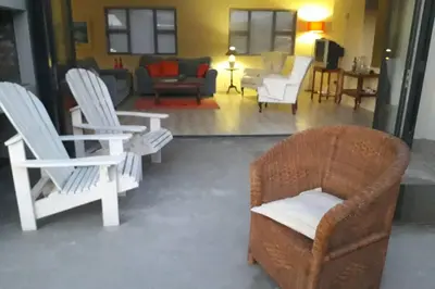 a living room with white chairs and a couch at Moondust near the ocean, food and wine in Hermanus