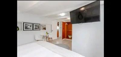 a bedroom with a bed and a tv on a wall at Antilles on Beach in Cape Town