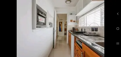 a kitchen with a white refrigerator and a sink at Antilles on Beach in Cape Town