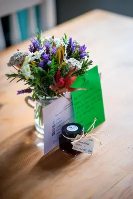 a vase of flowers and a card on a table at Moortop Cottages in Elgin