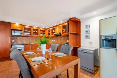 a kitchen with a wooden table with chairs and a refrigerator at Ocean View 701 in Cape Town