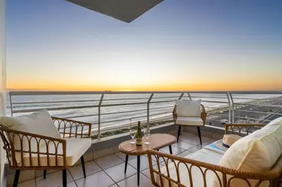 a balcony with chairs and a view of the ocean at Ocean View 701 in Cape Town