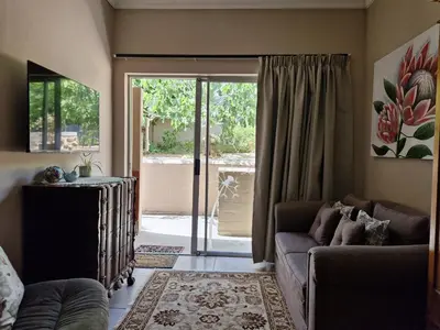 a living room with a couch and a sliding glass door at Goedehoop in Somerset West