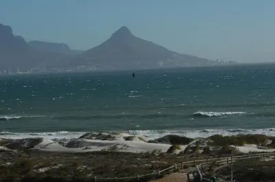 a view of the ocean with a mountain in the background at On The Beach Front Sea Spray in Bloubergstrand