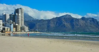 a beach with buildings and mountains in the background at OCEANPEARL 209 in Strand