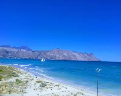 a beach with blue water and mountains in the background at OCEANPEARL 209 in Strand