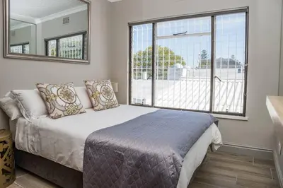 a bedroom with a bed and a large window at Apartment Claudia in Stellenbosch