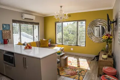 a kitchen and living room with yellow walls at Apartment Claudia in Stellenbosch