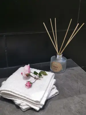 a towel with flowers on it next to a candle at The Blue Horizon House - Botrivier in Caledon