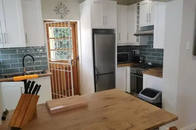 a kitchen with a refrigerator and a wooden table at The Blue Horizon House - Botrivier in Caledon