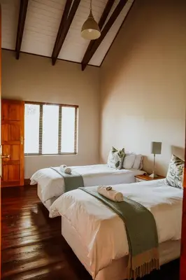 a bedroom with two beds in a room at Blue Crane Farm Lodge in Botrivier