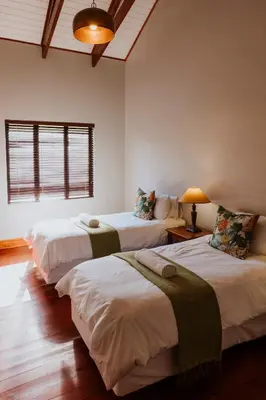 a room with three beds in a room at Blue Crane Farm Lodge in Botrivier