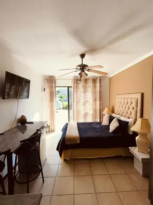 a bedroom with a bed and a ceiling fan at Sir James Self Catering in Cape Town