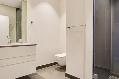 a bathroom with a toilet and a sink and a shower at Axis - Century City Self Catering Apartment in Cape Town