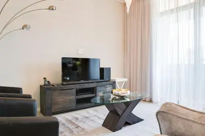 a living room with a tv and a glass table at Axis - Century City Self Catering Apartment in Cape Town