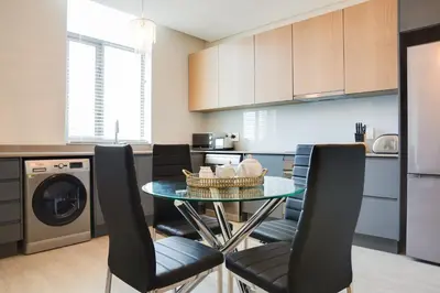 a kitchen with a dining room table and chairs at Axis - Century City Self Catering Apartment in Cape Town