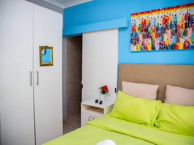 a bedroom with a green bed and a blue wall at Relaxing Guest Huse in the heart of Ndabeni in Cape Town