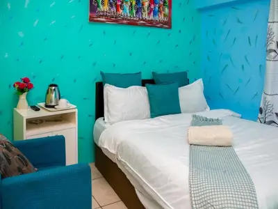 a blue bedroom with a bed and a blue wall at Relaxing Guest Huse in the heart of Ndabeni in Cape Town