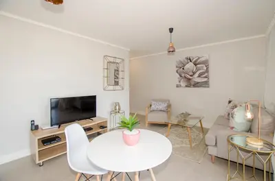 a living room with a table and a couch at Waters Edge Apartments in Cape Town