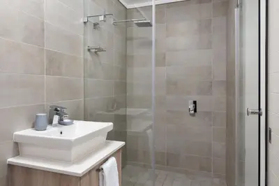 a bathroom with a sink and a shower at Waters Edge Apartments in Cape Town