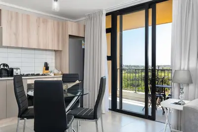 a kitchen and dining room with a table and chairs at Waters Edge Apartments in Cape Town
