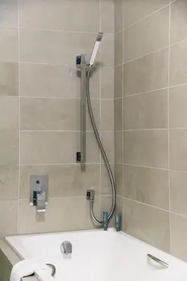 a bathroom with a shower with a tub and a sink at Waters Edge Apartments in Cape Town