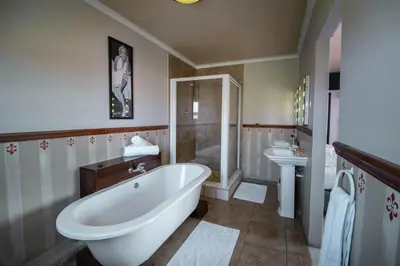 a bathroom with a tub and a shower and a sink at Broadway Tygervalley House in Cape Town