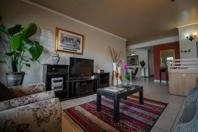 a living room with a couch and a coffee table at Broadway Tygervalley House in Cape Town
